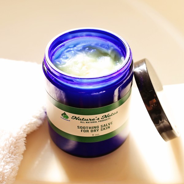 A 8 oz cobalt blue Nature's Notes jar with the light green, creamy Soothing Salve for Dry Skin.