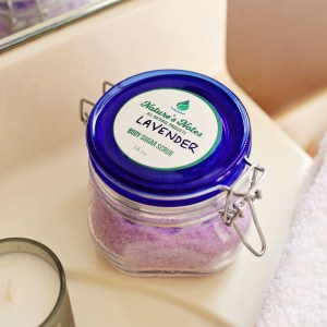 A clear hinged jar with cobalt blue glass lid containing Nature's Notes Body Sugar Scrub.